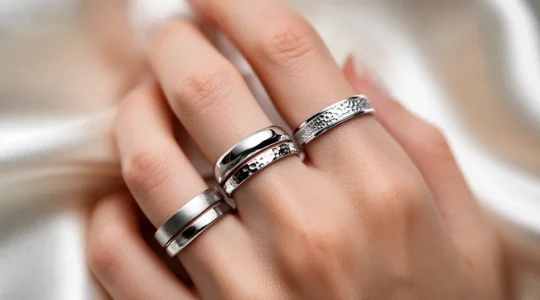 Close-up of platinum jewelry pieces on pristine skin showing hypoallergenic luxury