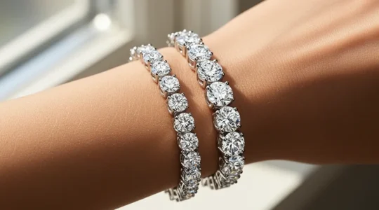 Close-up of two tennis bracelets showing 3-prong and 4-prong diamond settings on a wrist