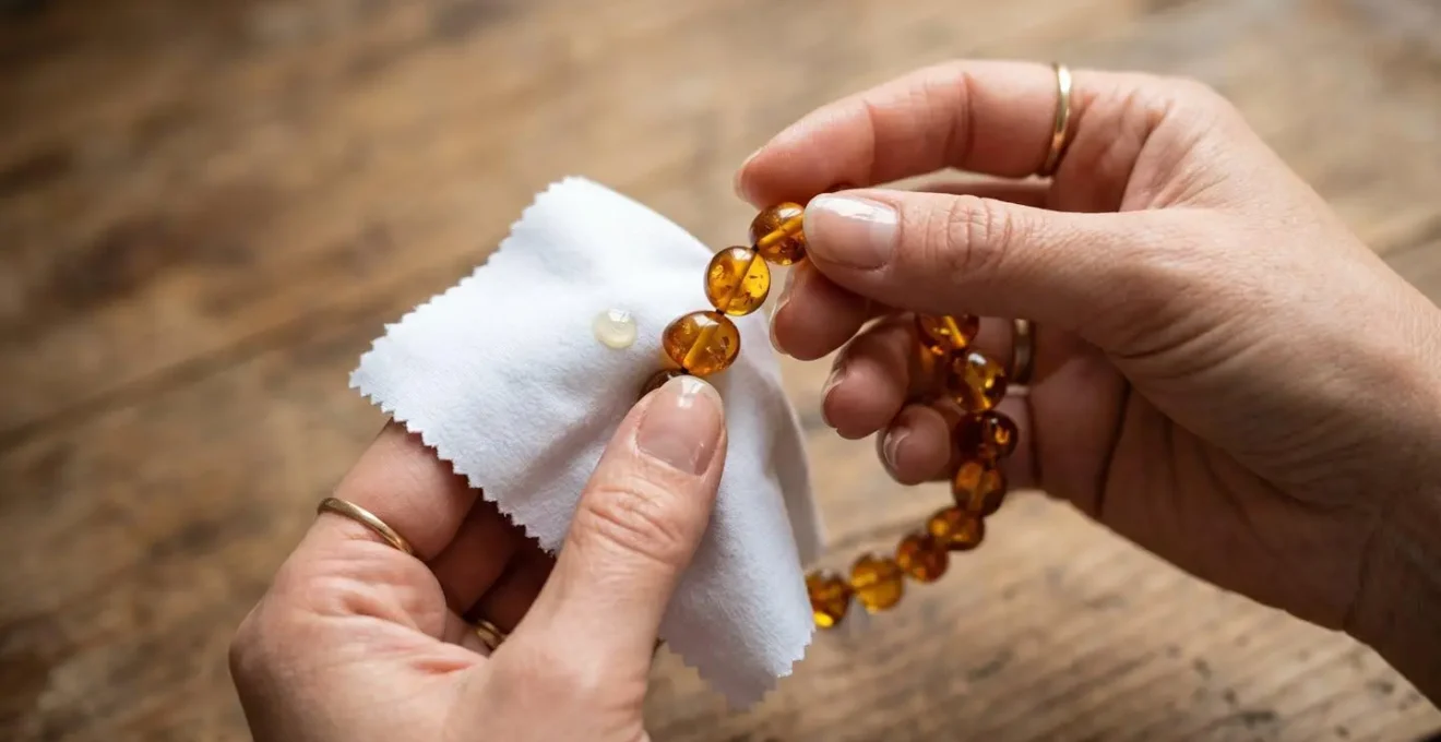 Hands gently cleaning Baltic amber bracelet with soft cloth and natural oil