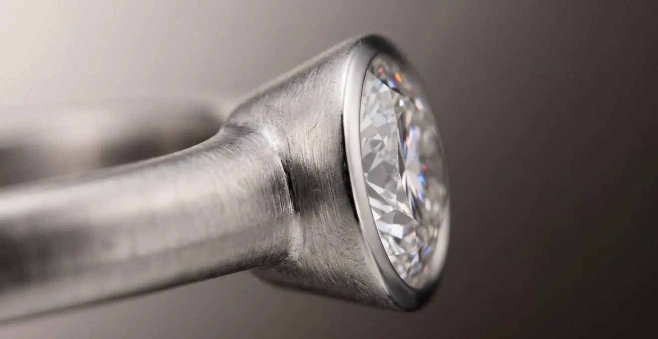 Macro view of bezel setting showing metal encircling diamond girdle