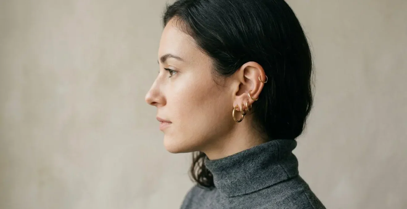 Close-up of ear with multiple graduated hoop earrings arranged from large to small