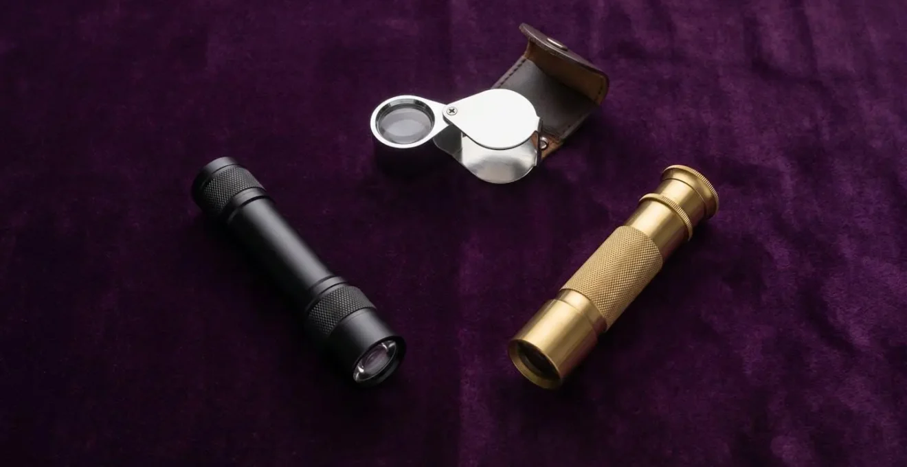 Overhead view of essential gemologist tools arranged on dark velvet surface
