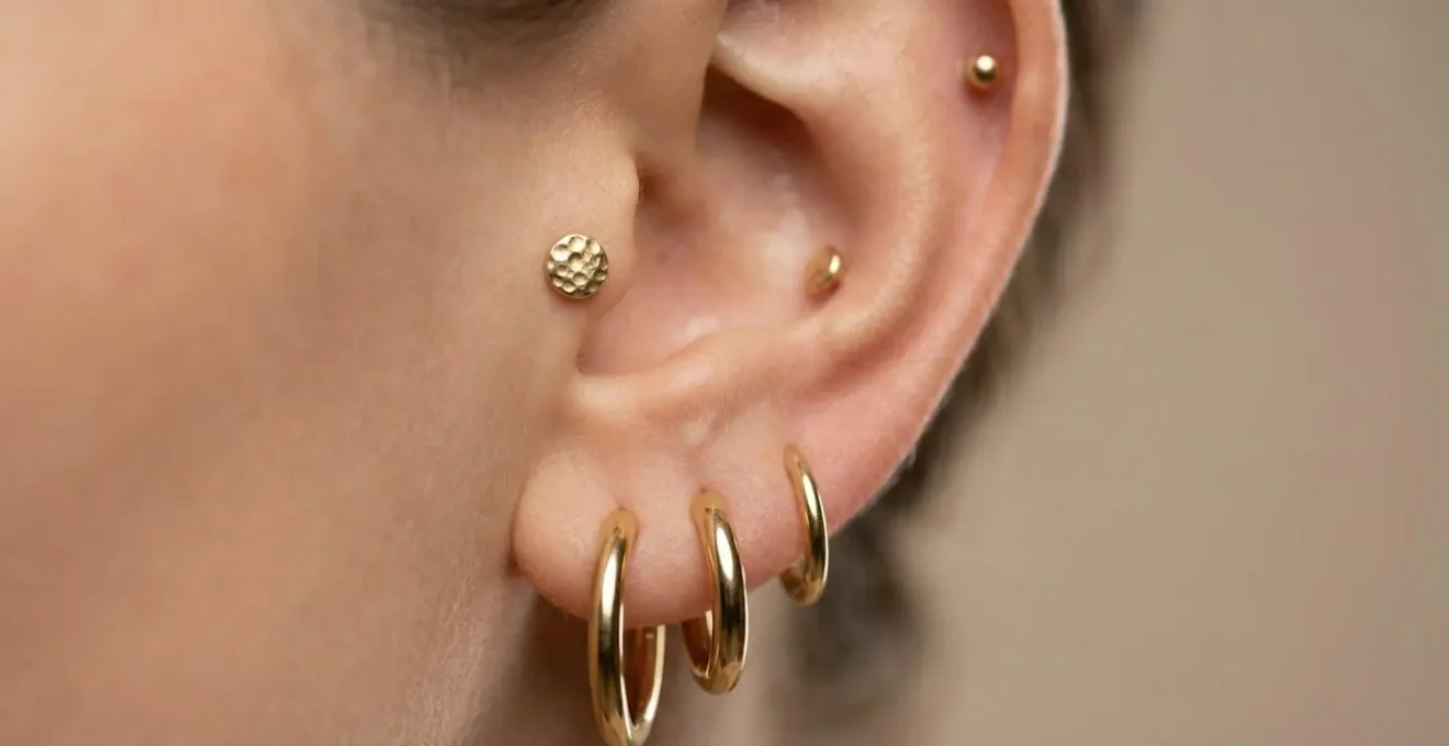 Close-up of an ear showcasing graduated hoop sizes with complementary studs